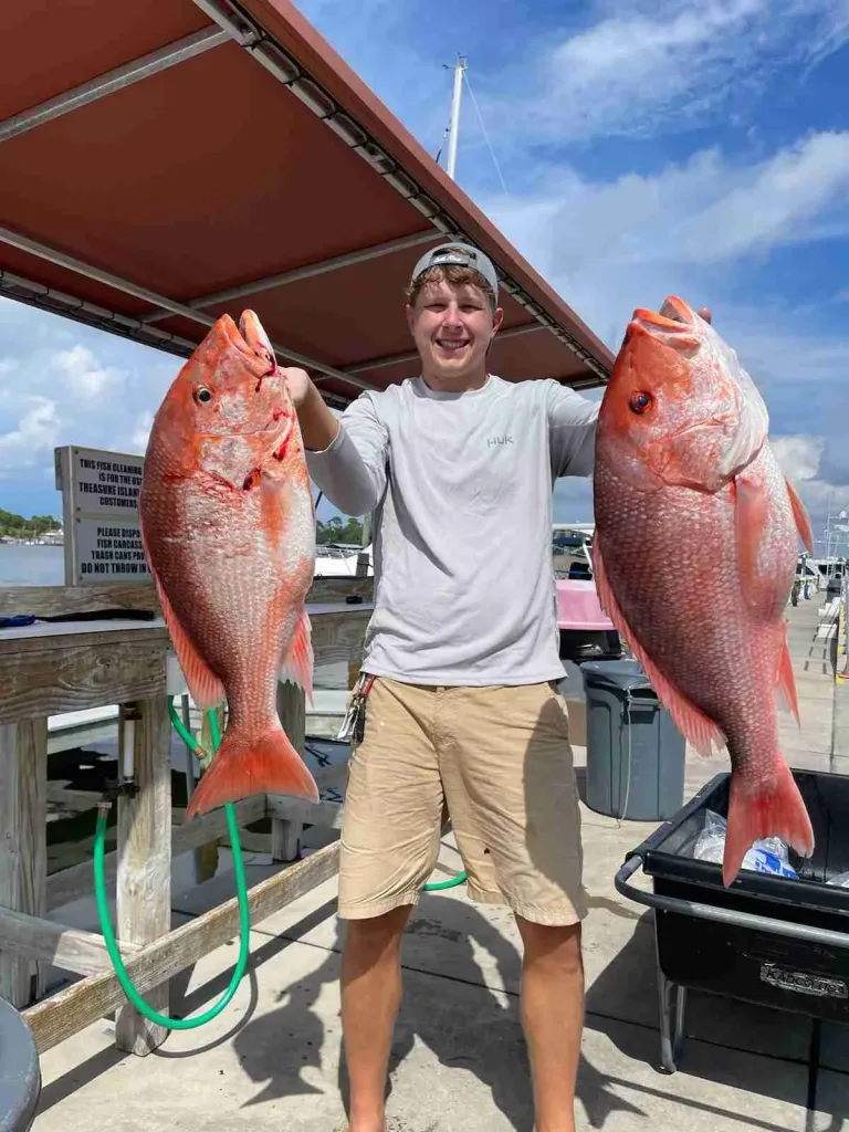 Happy client displaying 2 nice red snapper