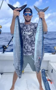 Captain Brock of Grinning Angler Charters holding 2 wahoo